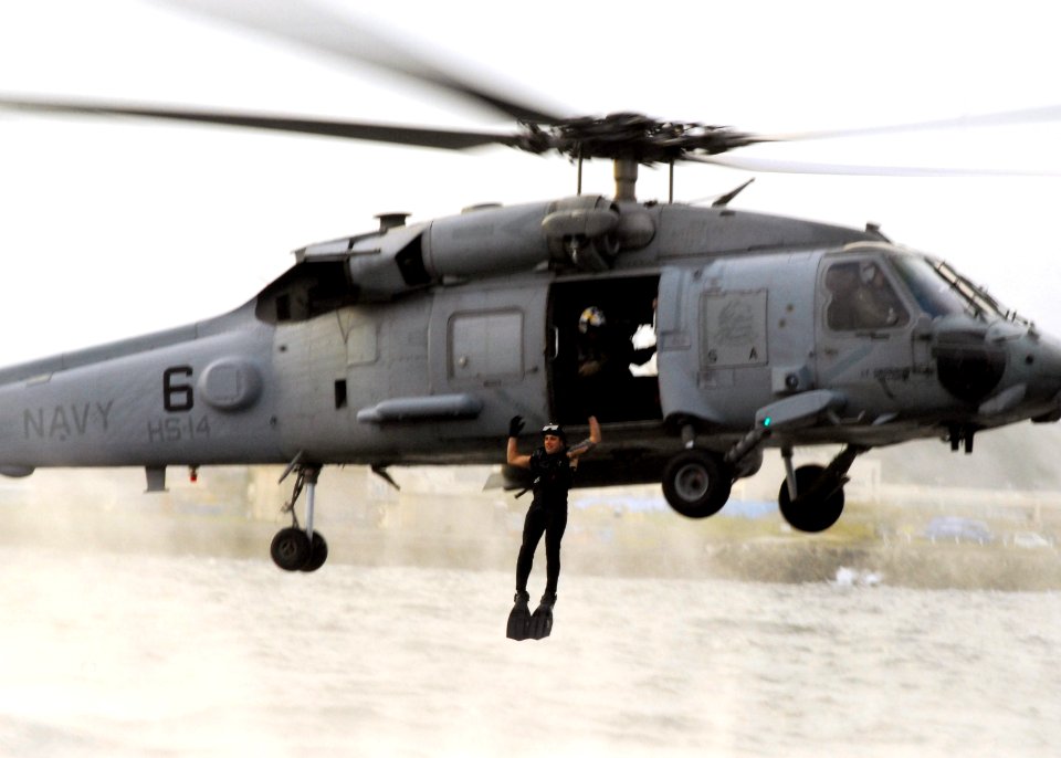US Navy 071015-N-2638R-009 A search and rescue (SAR) swimmer, assigned to the Chargers of Helicopter Anti-Submarine Squadron (HS) 14, jumps from an HH-60H Seahawk during SAR training at Fleet Activities Yokosuka
