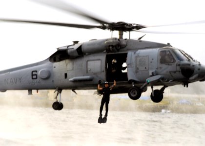 US Navy 071015-N-2638R-009 A search and rescue (SAR) swimmer, assigned to the Chargers of Helicopter Anti-Submarine Squadron (HS) 14, jumps from an HH-60H Seahawk during SAR training at Fleet Activities Yokosuka