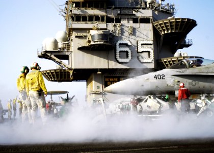 US Navy 071005-N-5681S-069 Flight deck personnel prepare to launch an F-A-18C Hornet attached to the Sidewinders of Strike Fighter Squadron (VFA) 86, from the flight deck of the nuclear-powered aircraft carrier USS Enterprise (