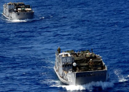 US Navy 071012-N-6710M-009 A landing craft utility prepares to enter the well deck of dock landing ship USS Tortuga (LSD 46) while transiting equipment photo