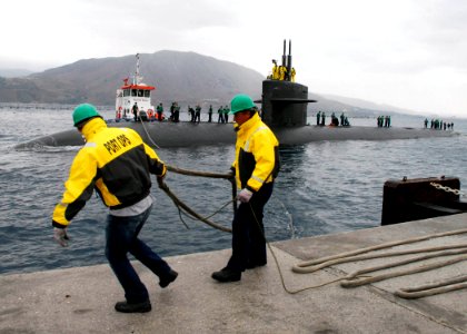US Navy 071015-N-0780F-003 U.S. Naval Support Activity employees assist with line handling as Los Angeles-class submarine USS Oklahoma City (SSN 723) arrives for a port visit