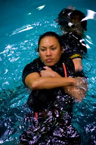 US Navy 071010-N-5319A-003 Airman Soonja Tyrell, a student at the Rescue Swimmer School at Naval Air Station Pensacola, relaxes while being buddy-towed during morning physical training in the pool