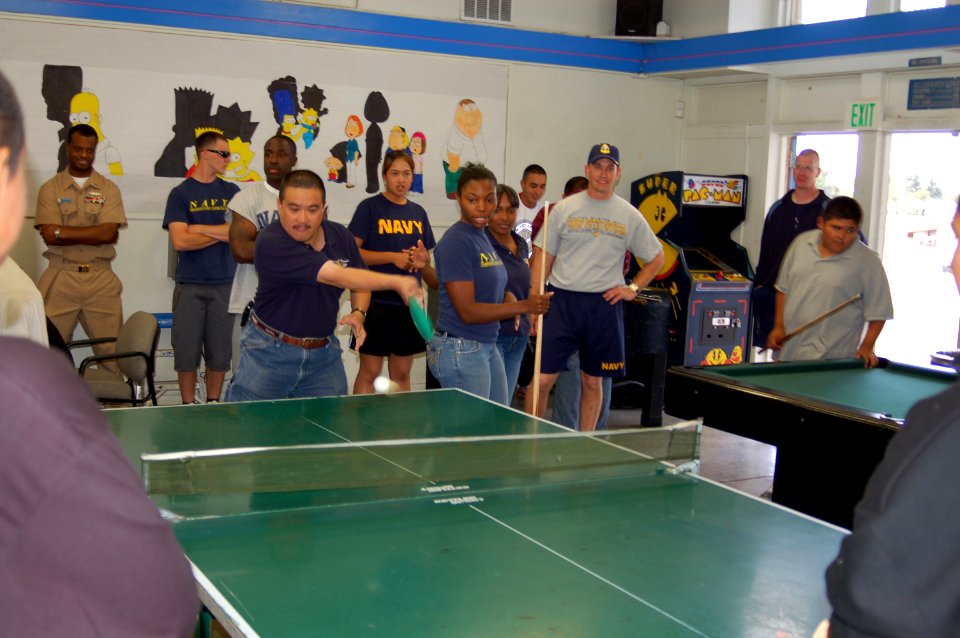 US Navy 071009-N-3570S-016 Master Chief Culinary Specialist Terry Delacruz, of Navy of Operational Support Center San Jose, hits the ball during a ping-pong match with teens at Tracy Wilson YMCA San Jose