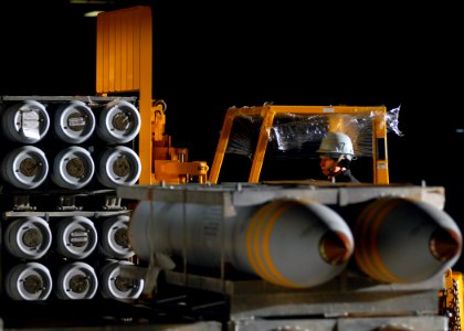 US Navy 071016-N-7981E-149 Aviation Ordnanceman Airman Brian Lusher uses a forklift to transport bombs onto a weapons elevator in the hangar bay of Nimitz-class aircraft carrier USS Abraham Lincoln (CVN 72) photo