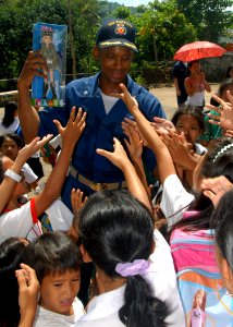 US Navy 071016-N-6710M-118 Cmdr. Todd A. Lewis, commanding officer of the USS Tortuga (LSD 46), hands out toys to the students of Gordon Heights Elementary School while conducting a community relations project in the Republic o photo