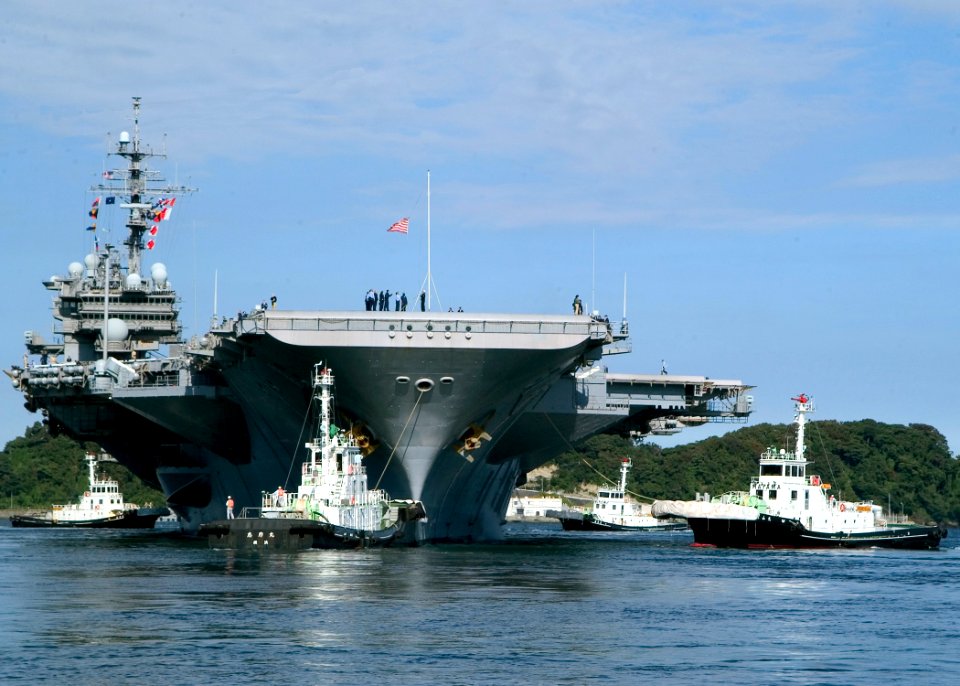 US Navy 071021-N-0483B-002 A Japanese harbor tugs assist USS Kitty Hawk (CV 63) depart Commander, Fleet Activities Yokosuka for its fall deployment