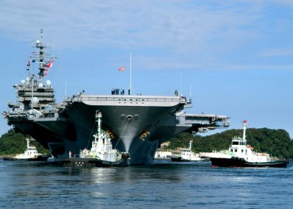 US Navy 071021-N-0483B-002 A Japanese harbor tugs assist USS Kitty Hawk (CV 63) depart Commander, Fleet Activities Yokosuka for its fall deployment