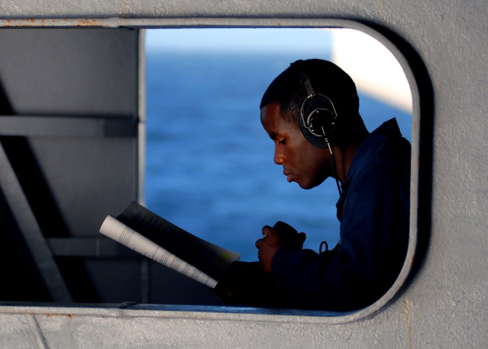 US Navy 071020-N-7981E-106 Yeoman Seaman Ernest Matthews studies advanced qualifications while standing by to relay messages using a sound-powered phone as the Nimitz-class aircraft carrier USS Abraham Lincoln (CVN 72)