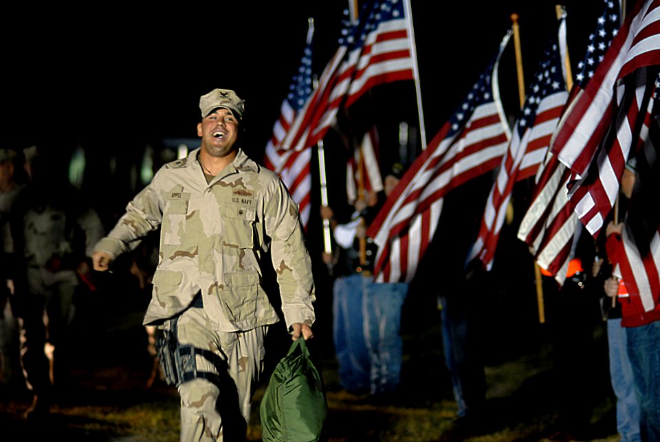 US Navy 071022-N-4515N-146 Quarter Master 2nd Class Nikolas Appel runs out to greet his wife and child following a 7 month deployment to Iraq with Riverine Squadron (RIVRON) 1