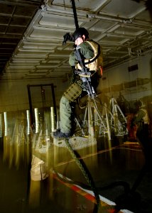 US Navy 071021-N-7981E-114 Master-at-Arms 3rd Class Owen Davis, assigned to Helicopter Visit, Board, Search and Seizure (HVBSS) Team 1, participates in fast-rope training photo