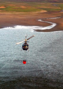 US Navy 071023-N-3069F-029 A civilian helicopter refills a bucket used to drop water in coordination with fire fighters and Navy pilots assigned to Helicopter Sea Combat Squadron (HSC) 85