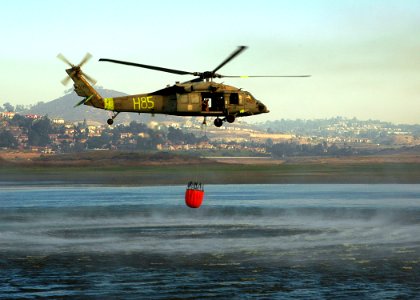 US Navy 071023-N-3069F-004 An MH-60S Seahawk assigned to Helicopter Sea Combat Squadron (HSC) 85, lifts a full 420-gallon extinguishing trough from a local reservoir near the raging wildfires in San Diego County