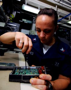 US Navy 071025-N-8132M-086 Electronics Technician 3rd Class Kristan Fries solders a loose component on a M-PA flight deck radio aboard nuclear-powered aircraft carrier USS Enterprise (CVN 65)