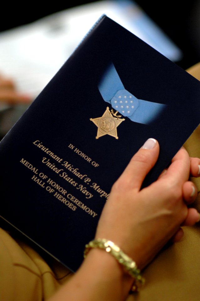 US Navy 071023-N-2653P-169 An attendee holds the Medal of Honor award program during a ceremony recognizing the actions of Navy SEAL Lt. Michael Murphy held at the Hall of Heroes inside the Pentagon