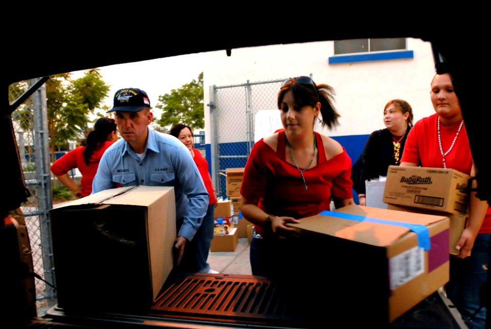 US Navy 071023-N-4776G-331 Personal Specialist Seaman Vasile Mesaros, assigned to Nimitz-Class aircraft carrier USS Ronald Reagan (CVN 76), helps local volunteers load a truck with supplies for an evacuation center in San Diego