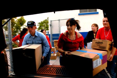 US Navy 071023-N-4776G-331 Personal Specialist Seaman Vasile Mesaros, assigned to Nimitz-Class aircraft carrier USS Ronald Reagan (CVN 76), helps local volunteers load a truck with supplies for an evacuation center in San Diego