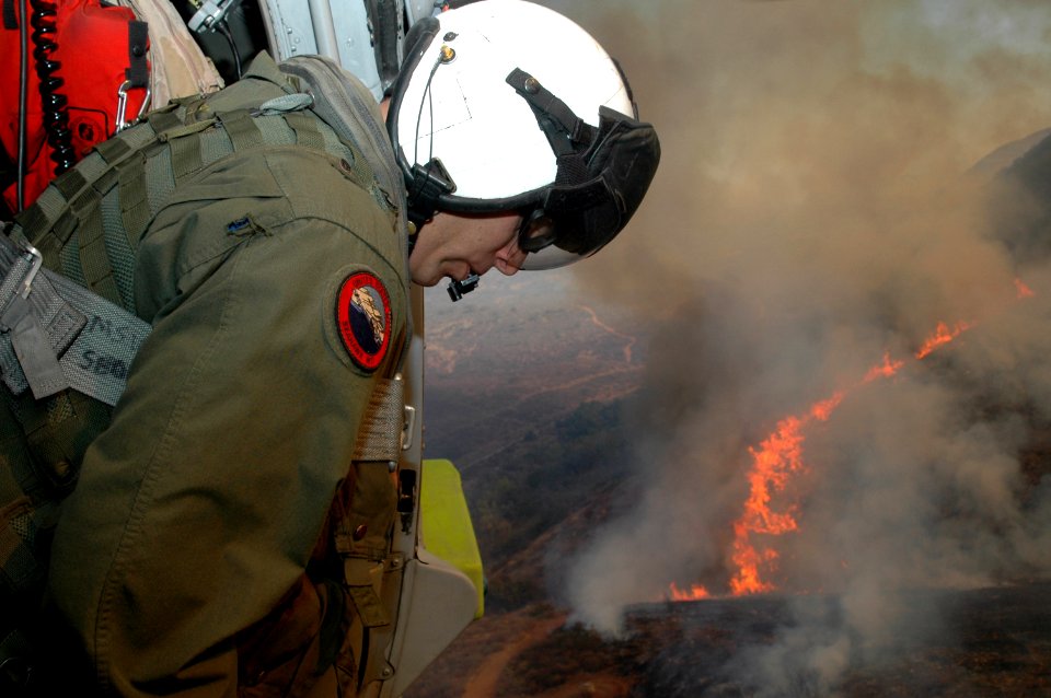 US Navy 071023-N-3069F-008 Chief Aviation Electronics Technician Rexford Sackett, assigned to Helicopter Sea Combat Squadron (HSC) 85, looks upon miles of burnt terrain as he and other Sailors prepare to help fend off the blaze
