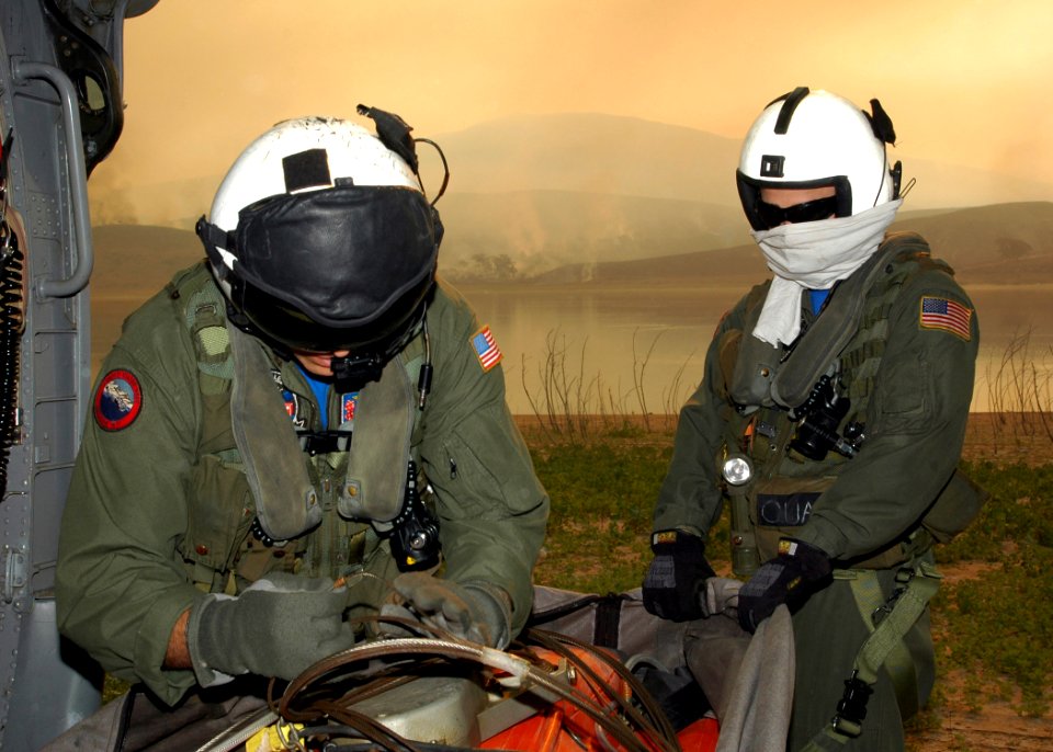 US Navy 071023-N-3069F-002 Chief Aviation Electronics Technician Rexford Sackett, left, and Aviation Warfare Systems Operator 3rd Class William Quadrino prepare a 420-gallon extinguishing trough used to dump water on the wildfi