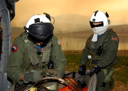 US Navy 071023-N-3069F-002 Chief Aviation Electronics Technician Rexford Sackett, left, and Aviation Warfare Systems Operator 3rd Class William Quadrino prepare a 420-gallon extinguishing trough used to dump water on the wildfi