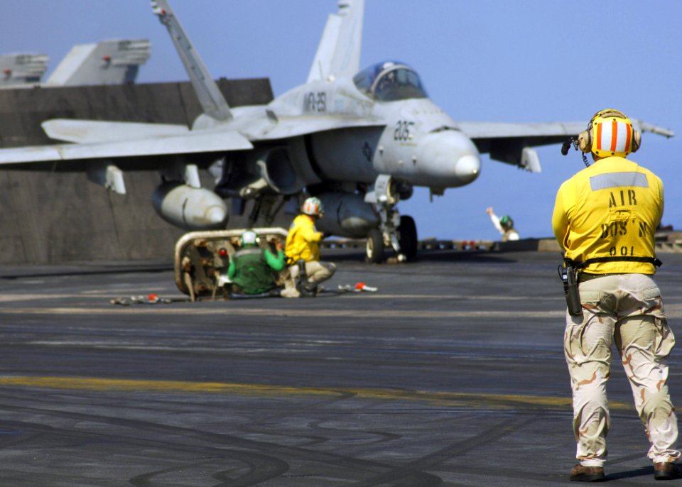 US Navy 071025-N-1598C-048 Chief Warrant Officer Kenneth Joubert observes the take off of an F-A-18C Hornet, attached to the Thunderbolts of Marine Fighter Attack Squadron (VMFA) 251, from the flight deck of the nuclear-powered
