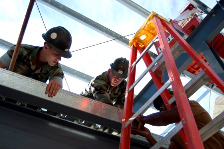 US Navy 071029-N-5253W-002 Seabees from Naval Mobile Construction Battalion (NMCB) 7, Detachment Yokosuka, move a metal beam into place at Fleet Activities Yokosuka