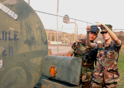 US Navy 071023-N-4973M-018 Hospital Corpsman 2nd Class Ashley Grabo and Seaman Letisha Begay test one of four 400-gallon portable water containers intended for victims of the San Diego wildfires on Turner Field at Naval Amphibi photo