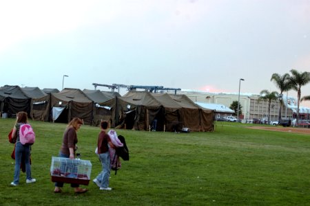 US Navy 071023-N-4973M-003 Victims of the San Diego wildfires move personal items and pets into a 500-person tent camp on Turner Field at Naval Amphibious Base Coronado photo