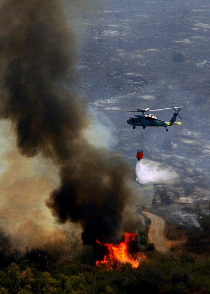 US Navy 071023-N-3069F-043 An MH-60S Seahawk assigned to Helicopter Sea Combat Squadron (HSC) 85, dumps water from a full 420-gallon extinguishing trough