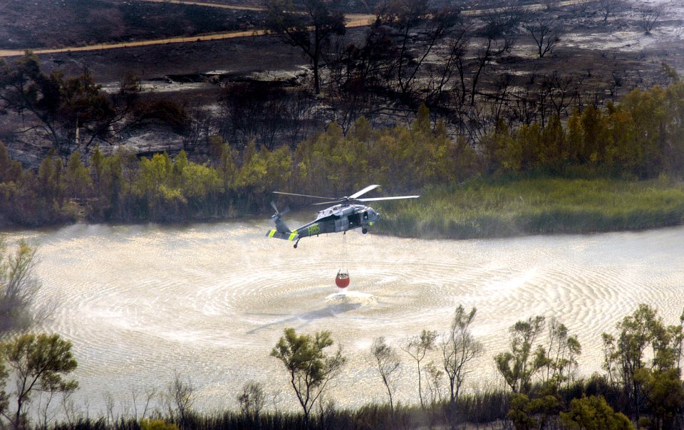US Navy 071024-N-6597H-086 An MH-60S Seahawk helicopter retrieves water from a lake near the wildfires in San Diego