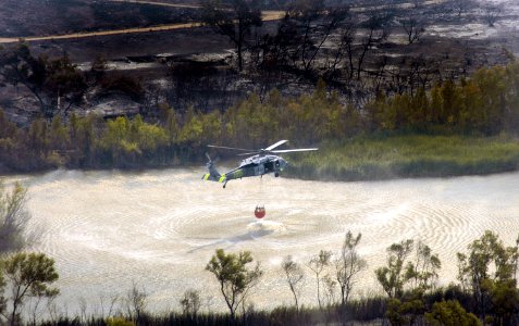 US Navy 071024-N-6597H-086 An MH-60S Seahawk helicopter retrieves water from a lake near the wildfires in San Diego