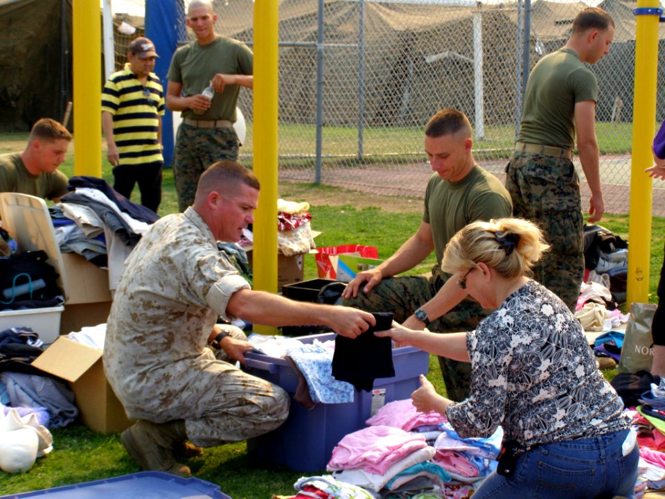 US Navy 071024-N-0000X-056 Evacuees from the San Diego wildfires gather clothing donated by San Diego area high schools on Turner Field at Naval Amphibious Base Coronado