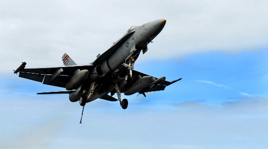 US Navy 090626-N-0684R-061 An F-A-18C Hornet assigned to the Death Rattlers of Marine Strike Fighter Squadron (VMFA) 323 flies over the aircraft carrier USS John C. Stennis (CVN 74)