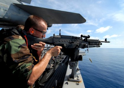 US Navy 090623-N-6720T-048 Seaman William Current, assigned to the Operations department, security division, aboard the aircraft carrier USS George Washington (CVN 73), fires an M-240B machine gun