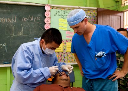 US Navy 090624-N-1722M-674 Malaysian Army Dentist Capt. Chan Ichizensg examines a patient at Seberan Tayor Primary School as U.S. Navy dentist Lt. Brant Cullen looks