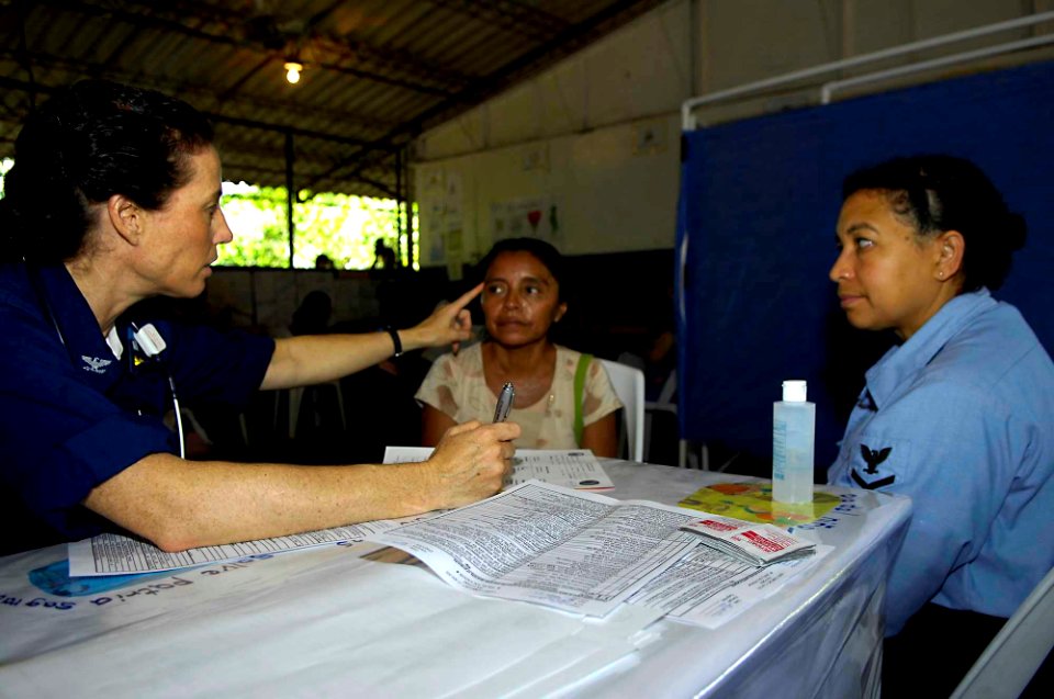 US Navy 090629-F-7923S-066 apt. Colleen Gallagher and Religious Programs Specialist 3rd Class Elvira Reyes explain the importance of proper eye maintenance at a primary school in El Carmen