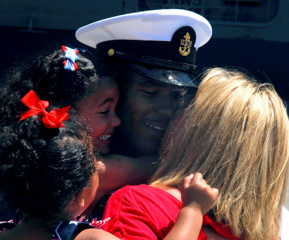 US Navy 090629-N-7780S-020 First kiss winner Chief Aviation Structural Mechanic Rick Mason greets his wife and his two daughters after the aircraft carrier USS John C. Stennis (CVN 74) arrives in Everett, Wash