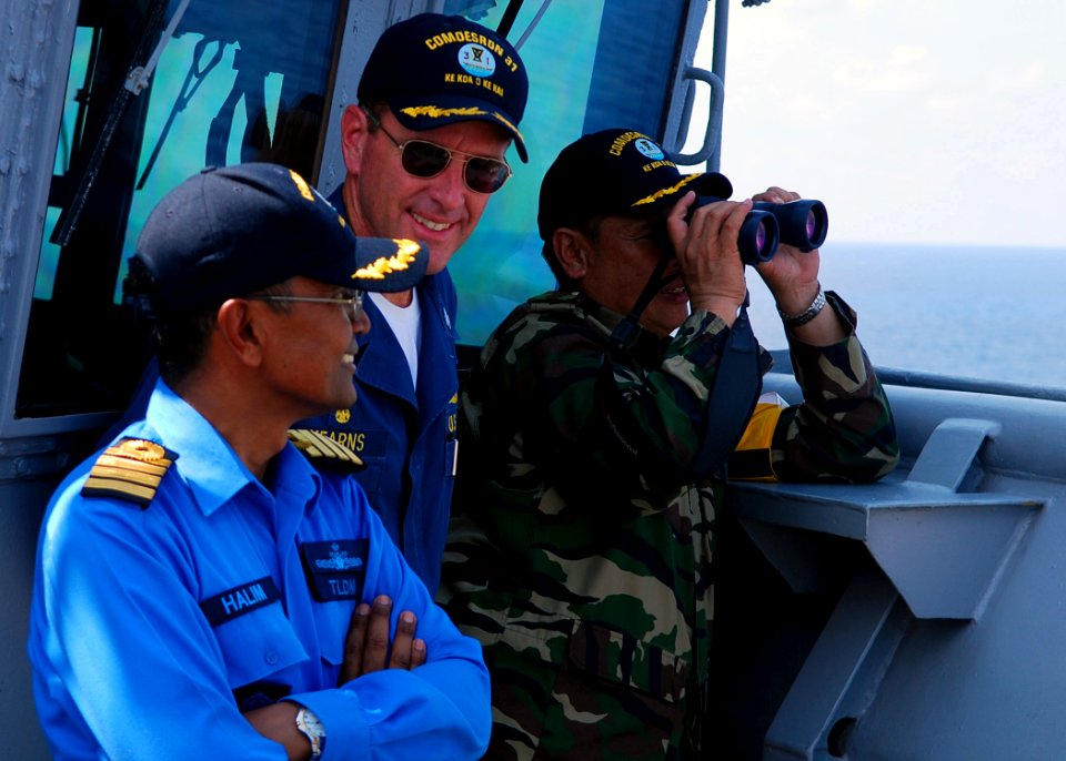 US Navy 090628-N-5207L-154 Royal Malaysian Navy Capt. Halim Bin Maulud, Commodore William Kearns III, Commander, Task Group 73.5, and Malaysian Army Col. Stephen Mundaw watch a surface gunnery exercise from the bridge wing of U