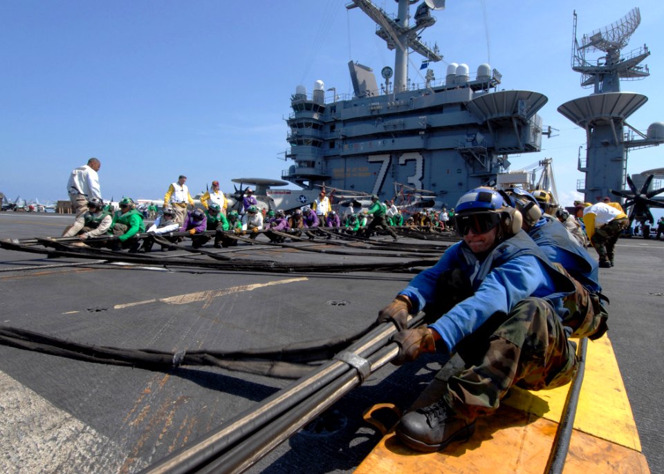 US Navy 090626-N-6720T-028 Sailors assigned to the air department of the aircraft carrier USS George Washington (CVN 73) prepare to raise an aircraft barricade during flight deck drills