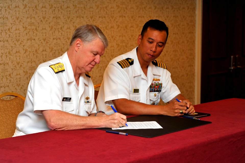 US Navy 090625-N-8273J-032 Chief of Naval Operations (CNO) Adm. Gary Roughead sings a memorandum of understanding with Capt. Joe DeLeon, president of the Naval Officers Mentorship Program (NOMA)