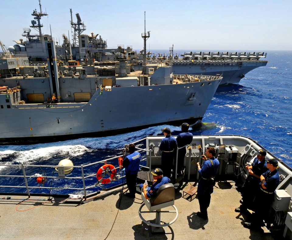 US Navy 090627-N-5345W-006 Cmdr. Christopher Stopyra, commanding officer of USS Fort McHenry (LSD 43), along with other Sailors aboard the amphibious dock landing ship, watch from the conning station as their ship receives fuel