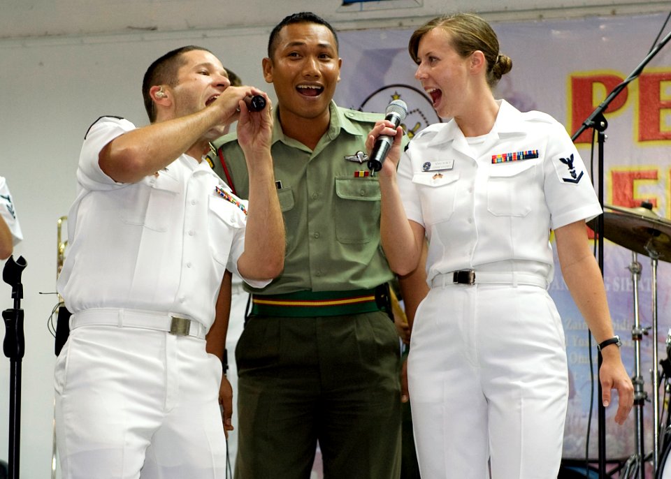 US Navy 090626-N-1722M-221 Musician 1st Class Bradley Blanchard and Musician 3rd Class Nina Church, both assigned to the U.S. 7th Fleet Rock Band Orient Express, sing the Beatles song