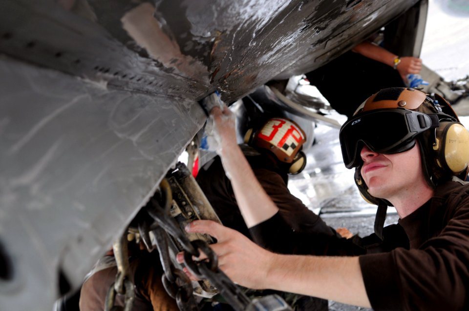 US Navy 090701-N-3610L-122 Aviation Electrician's Mate Airman Joseph Dawson scrubs the under-side of an F-A-18C Hornet, assigned to the Stingers of Strike Fighter Squadron (VFA) 113