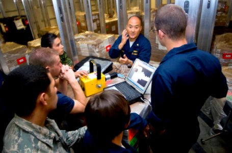 US Navy 090627-N-9689V-002 Dental officer-in-charge teaches Pacific Partnership 2009 dental team members from Canada, the U.S. Navy and U.S. Air Force how to operate a portable digital x-ray machine aboard USNS Richard E. Byrd photo