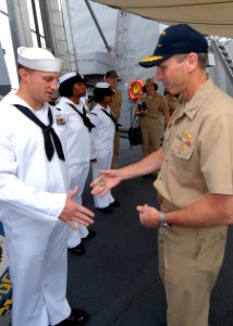 US Navy 090630-N-0486G-003 Adm. Jonathan W. Greenert, commander, U.S. Fleet Forces Command, presents a coin to Interior Communications Electrician 2nd Class Ronald Remillard during a visit to the guided-missile destroyer USS Fa