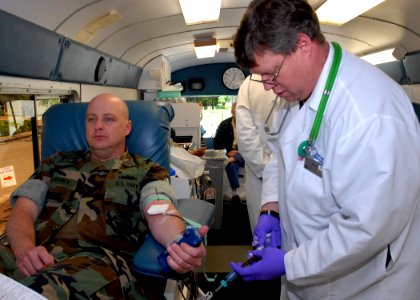 US Navy 090630-N-4649C-001 Eric Young, a mobile collection technician from the Puget Sound Blood Center, collects blood from Lt.j.g. James Godfrey, stationed at the Marine Corps Security Forces Battalion, during a blood drive