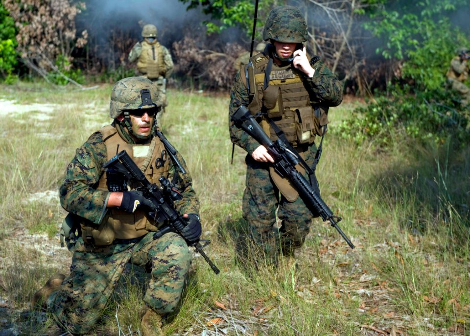 US Navy 090701-N-1722M-293 Staff Sgt. Ken Fall, left, and Lance Cpl. Clayton Sharrard secure a perimeter as they communicate with other U.S. Marines during a combined amphibious landing exercise