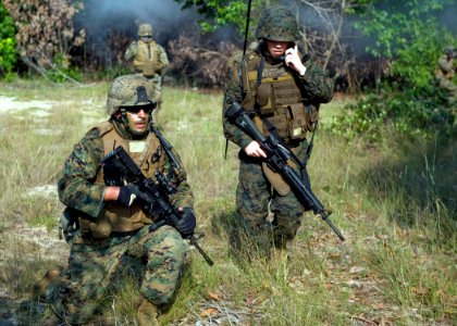 US Navy 090701-N-1722M-293 Staff Sgt. Ken Fall, left, and Lance Cpl. Clayton Sharrard secure a perimeter as they communicate with other U.S. Marines during a combined amphibious landing exercise