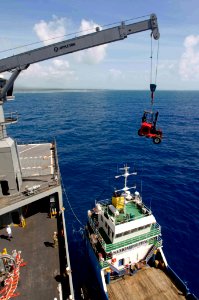 US Navy 090630-N-9689V-003 The Military Sealift Command dry cargo-ammunition ship USNS Richard E. Byrd (T-AKE 4) cranes cargo across decks to a local Samoan shipping vessel that will help ferry medical and engineering equipment