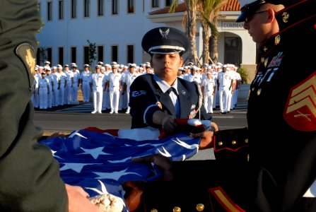 US Navy 090702-N-3289E-067 taff Sgt. Michelle Barboza unfolds the National ensign at Naval Station Rota Spain, during the annual flag raising ceremony
