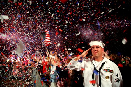 US Navy 090704-N-3271W-343 Mass Communication Specialist 2nd Class Scott Webb salutes as the American flag is presented on stage during the Boston Pops Fireworks Spectacular at the Charles River Esplanade